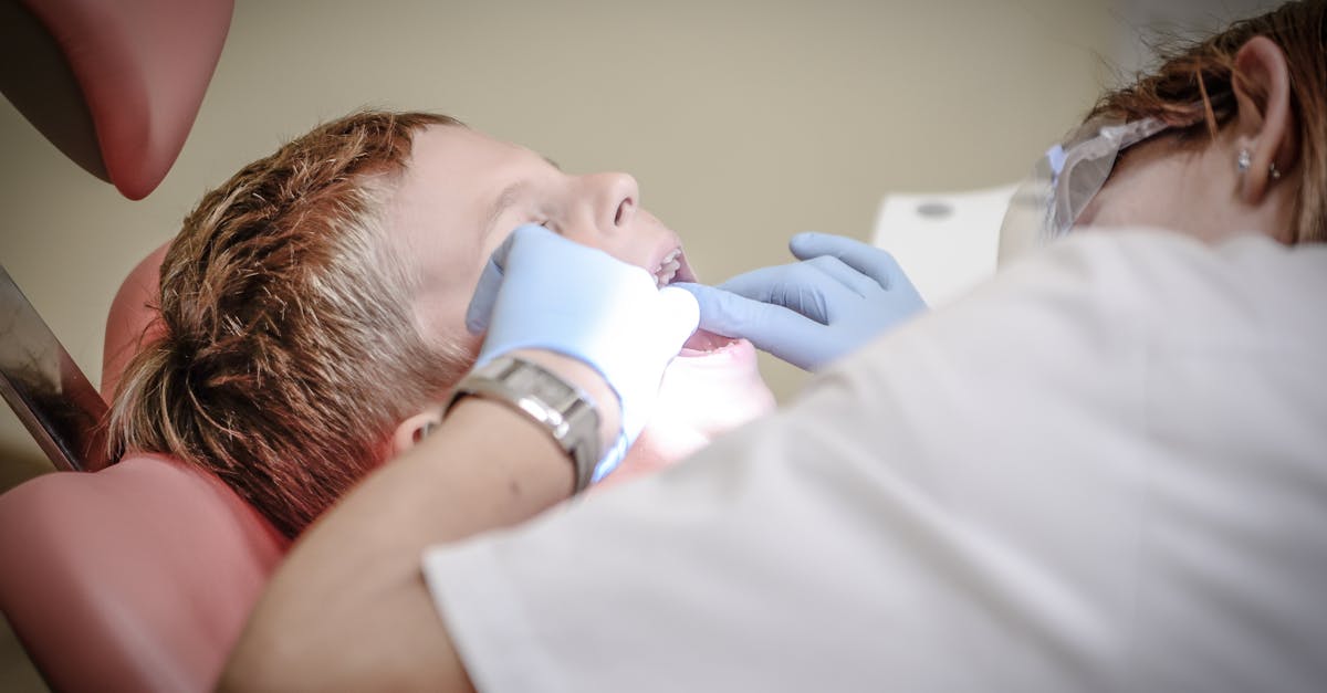 a young boy receiving a dental examination by a professional dentist in a clinic setting
